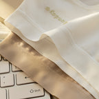 Cream Shelliy Brief folded briefs in cream and beige stacked on a white keyboard — Flat-lay
